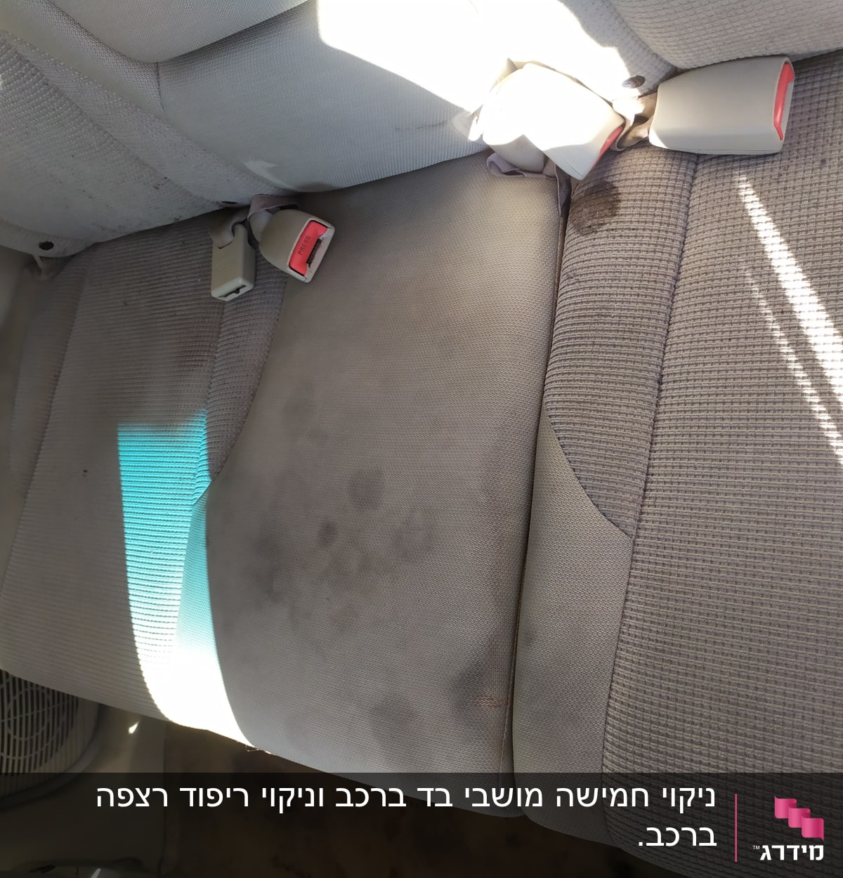 מושב רכב עם כתמים כהים על הבד האפור